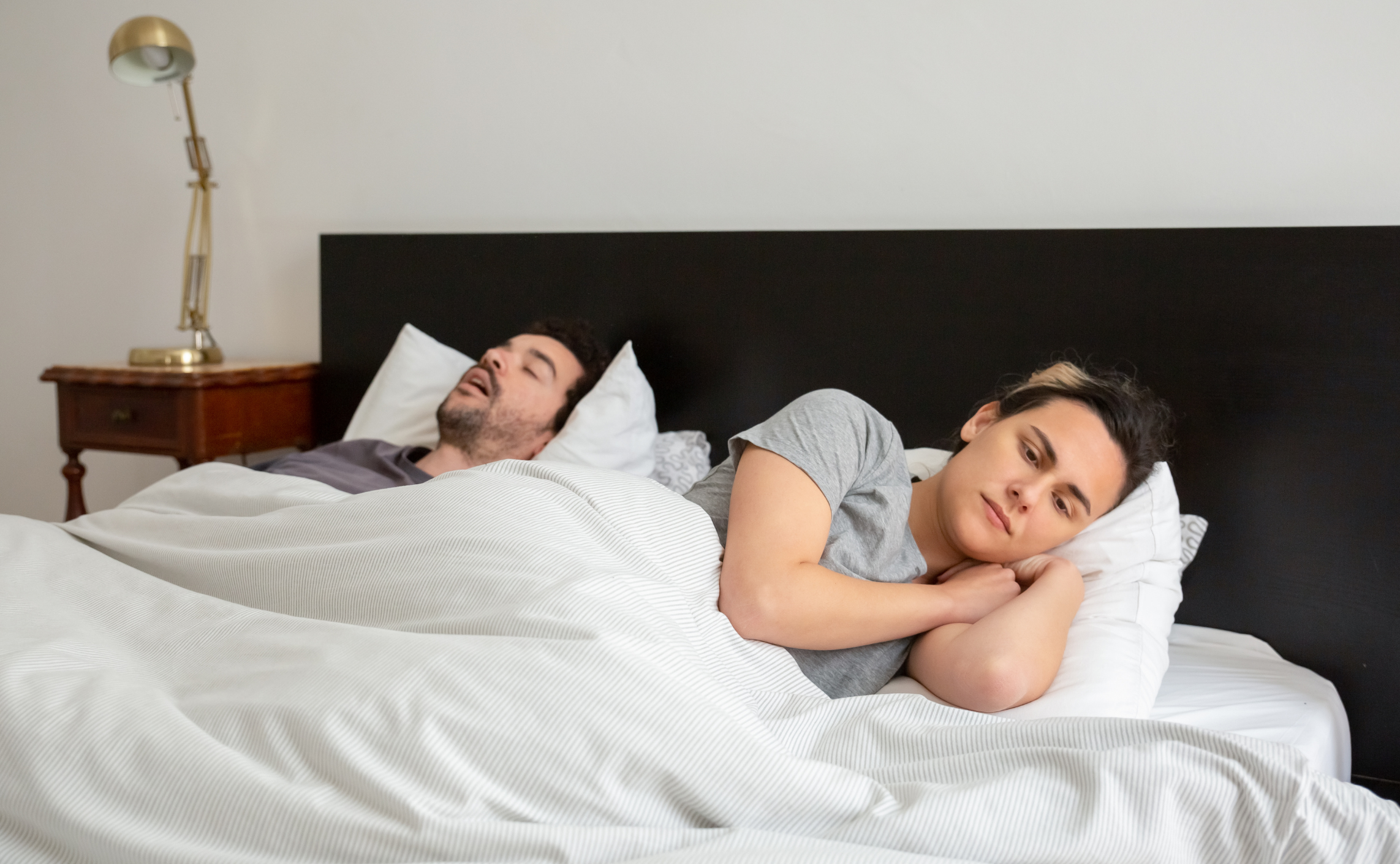 Man snoring while sleep next to woman