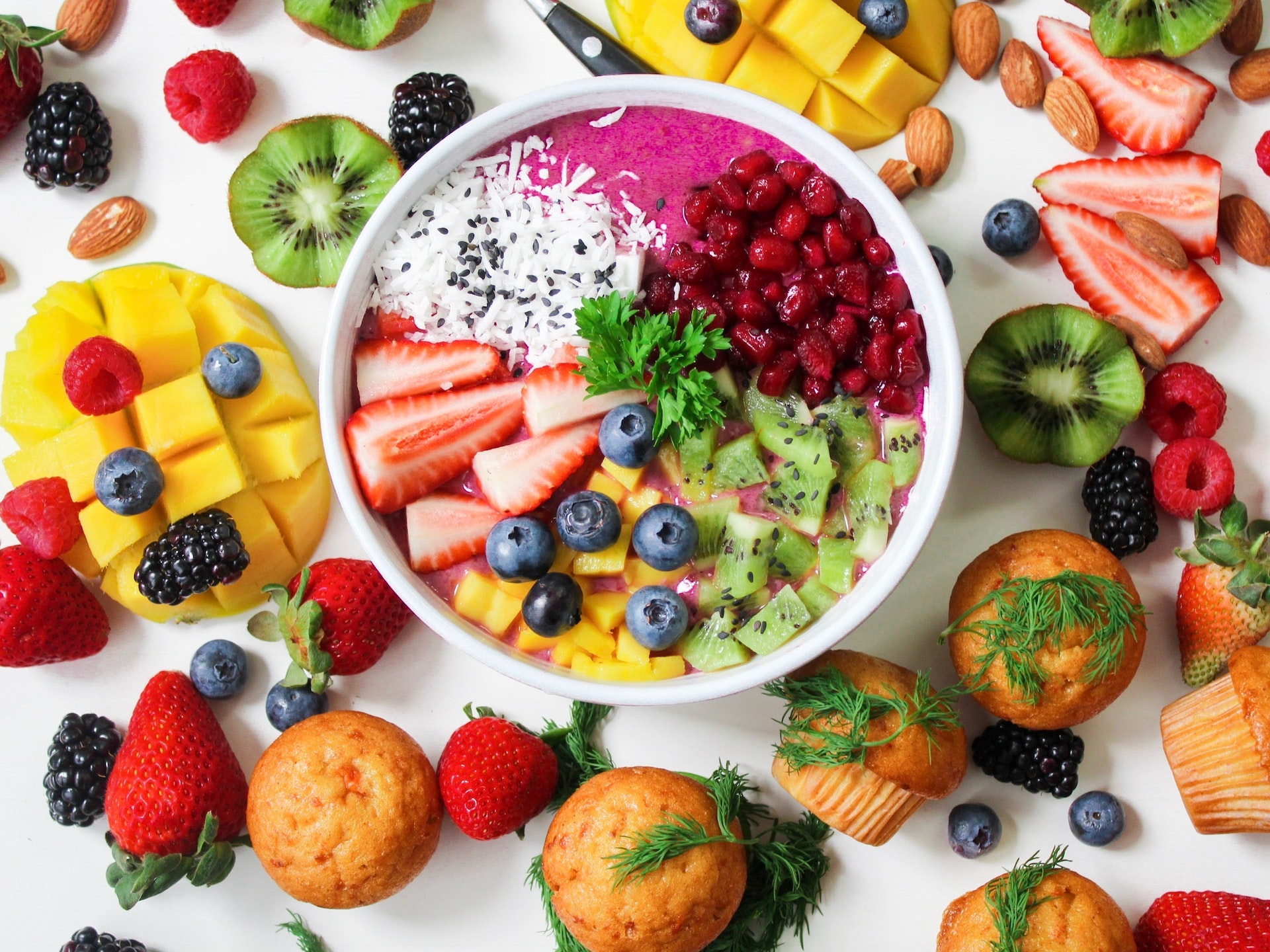 Table with breakfast foods and smoothie bowl